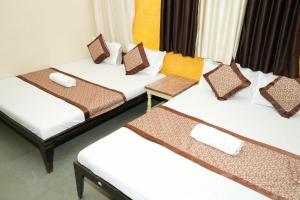 a group of three beds in a room at Hotel laxminarayan niwas in Shirdi +15 photos