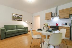 a living room with a couch and a table and chairs at NEW Tocai – in via Rastello per 4 pp in Gorizia