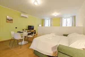 a bedroom with a white bed and a table and chairs at NEW Tocai – in via Rastello per 4 pp in Gorizia