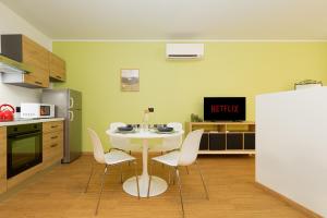 a kitchen with a white table and chairs in a room at NEW Tocai – in via Rastello per 4 pp in Gorizia