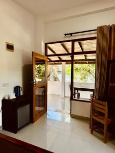 a living room with a door open to a patio at Rupas Hotel in Arugam Bay