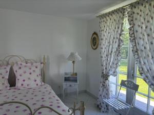 a bedroom with a pink bed and a window at Les 4 saisons in Menneville
