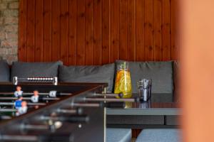 a table with a yellow bottle on top of a couch at Indok Vendégház in Abádszalók