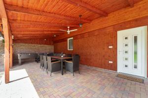 a patio with a table and chairs and a ceiling at Indok Vendégház in Abádszalók