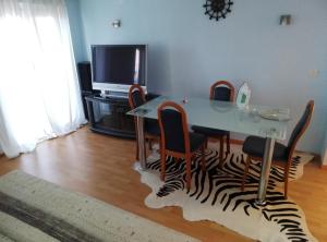 a dining room with a table and chairs with a zebra rug at 3 Zimmer Wohnung in Sutomore