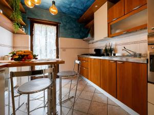 a kitchen with a counter and stools in a room at Casa di Iaio - Wi-Fi Netflix Home Cinema in Gorizia