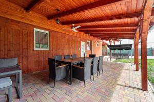 a patio with a table and chairs and a ceiling fan at Indok Vendégház in Abádszalók