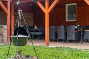 a pot hanging on a pole next to a fire at Indok Vendégház in Abádszalók +7 photos