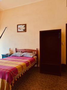 a bedroom with a bed and a picture on the wall at Casa Colibri La Punta in Brisas de Zicatela