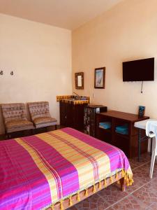a bedroom with a bed and a flat screen tv at Casa Colibri La Punta in Brisas de Zicatela +21 photos