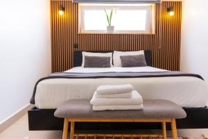 a bedroom with a large bed and a bench with towels on it at Cantinho da Susana in Coimbra