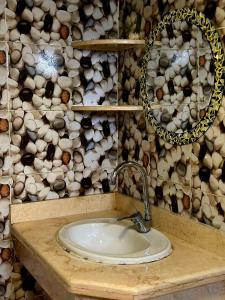a bathroom with a sink and a wall of logs at Moroohouse in Dahab +13 photos