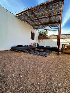 two beds under a pergola on the side of a building at Moroohouse in Dahab