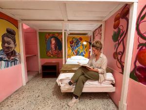 a woman sitting on a bed in a play house at Lienzo Hostal Popayán in Popayan