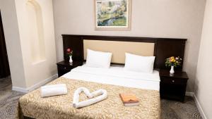 a hotel room with a bed with two heart shaped towels at Premier Hotel in Baku