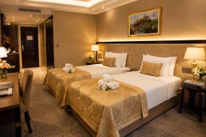 a hotel room with two beds with flowers on them at Premier Hotel in Baku