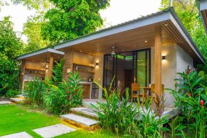 a small house in a garden with some plants at Serenity Bungalow in Cocles