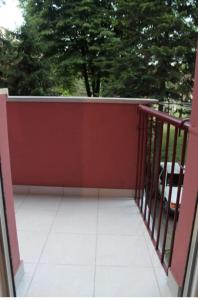a red fence on a balcony with trees in the background at Moj Mali Hotel in Valjevo