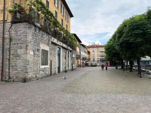 a cobblestone street in a city with people walking down it at The Nest in Mandello del Lario
