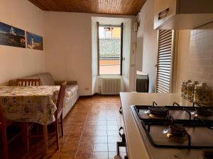 a kitchen with a stove and a table and a window at The Nest in Mandello del Lario