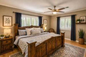 a bedroom with a wooden bed and a ceiling fan at Pub, Hot Tub, Game Room, Monkey Island Waterfront in Afton +37 photos
