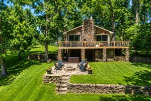 a house with a deck on top of a yard at Pub, Hot Tub, Game Room, Monkey Island Waterfront in Afton