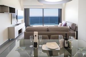 a living room with a couch and a table with wine glasses at Benidorm Luxury Residential in Benidorm