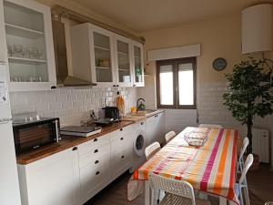 a kitchen with white cabinets and a table with a table cloth at Casa dos Andrades in Belmonte