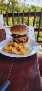 Ein Teller mit einem Hamburger und Pommes frites auf einem Tisch in der Unterkunft Indabuch in Rustenburg
