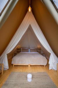 a bedroom in a tent with a bed in it at Amaraxe Ecoglamping in Miñortos +32 photos