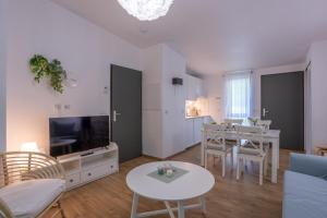 a living room with a tv and a dining room at Les Charmes C18 - Le Val Joly in Eppe-Sauvage