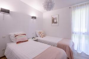 two beds in a room with white walls and a window at Les Charmes C18 - Le Val Joly in Eppe-Sauvage