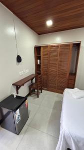 a bedroom with a bed and a table and a desk at Suítes Aymoré in Itacaré