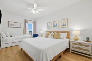 a white bedroom with two beds and a ceiling fan at Riviera Dunes 503 in Perdido Key +60 photos