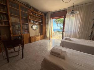 a bedroom with two beds and a desk and a window at Vista Mare a 300 mt dalla spiaggia in Cariati