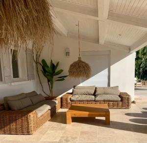 two wicker couches and a coffee table on a patio at Cruciata in Pietrosella
