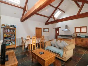 a living room with a couch and a table at Riverside Barn in Gilwern