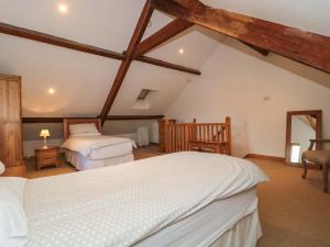 a attic bedroom with two beds and a mirror at Riverside Barn in Gilwern