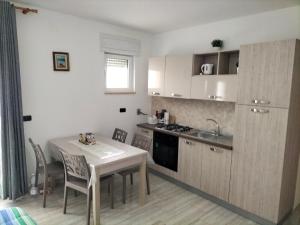 a small kitchen with a table and a table and chairs at Casa Vacanze " ORTE " in Otranto