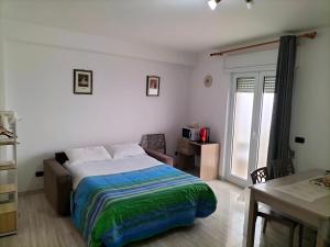a bedroom with a bed and a table and a window at Casa Vacanze " ORTE " in Otranto