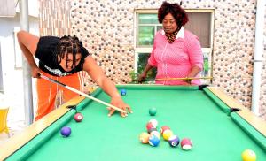 two women playing a game of pool on a pool table at P Meridian Hotels in Awoyaya +18 photos