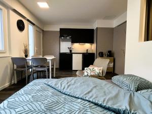 a bedroom with a bed and a kitchen and a table at Studio de l'étoile in Bavans