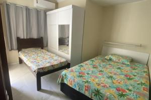 a small bedroom with a bed and a mirror at Casa do Arruda na tabuba in Caucaia
