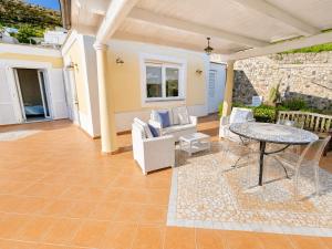 a patio with a table and chairs and a table at Maridea - Villetta Brezza Marina in Ponza +19 photos