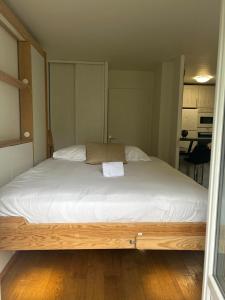 a large bed in a small room with white sheets at Studio Disney Paris in Bailly-Romainvilliers