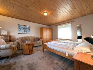 a bedroom with a bed and a couch and a table at Nordseehof Reitz in Friedrichskoog