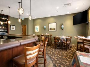 a bar in a restaurant with tables and chairs at Ocean Landings Resort Cocoa Beach Port Canaveral in Cocoa Beach