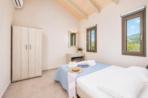 a white bedroom with a bed and a window at Villa Gerasmia in Trapezaki +12 photos