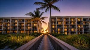 a hotel with palm trees in front of a building at Ocean Landings Resort Cocoa Beach Port Canaveral in Cocoa Beach