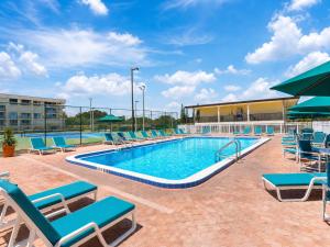 a pool at a hotel with chairs and a building at Ocean Landings Resort Cocoa Beach Port Canaveral in Cocoa Beach